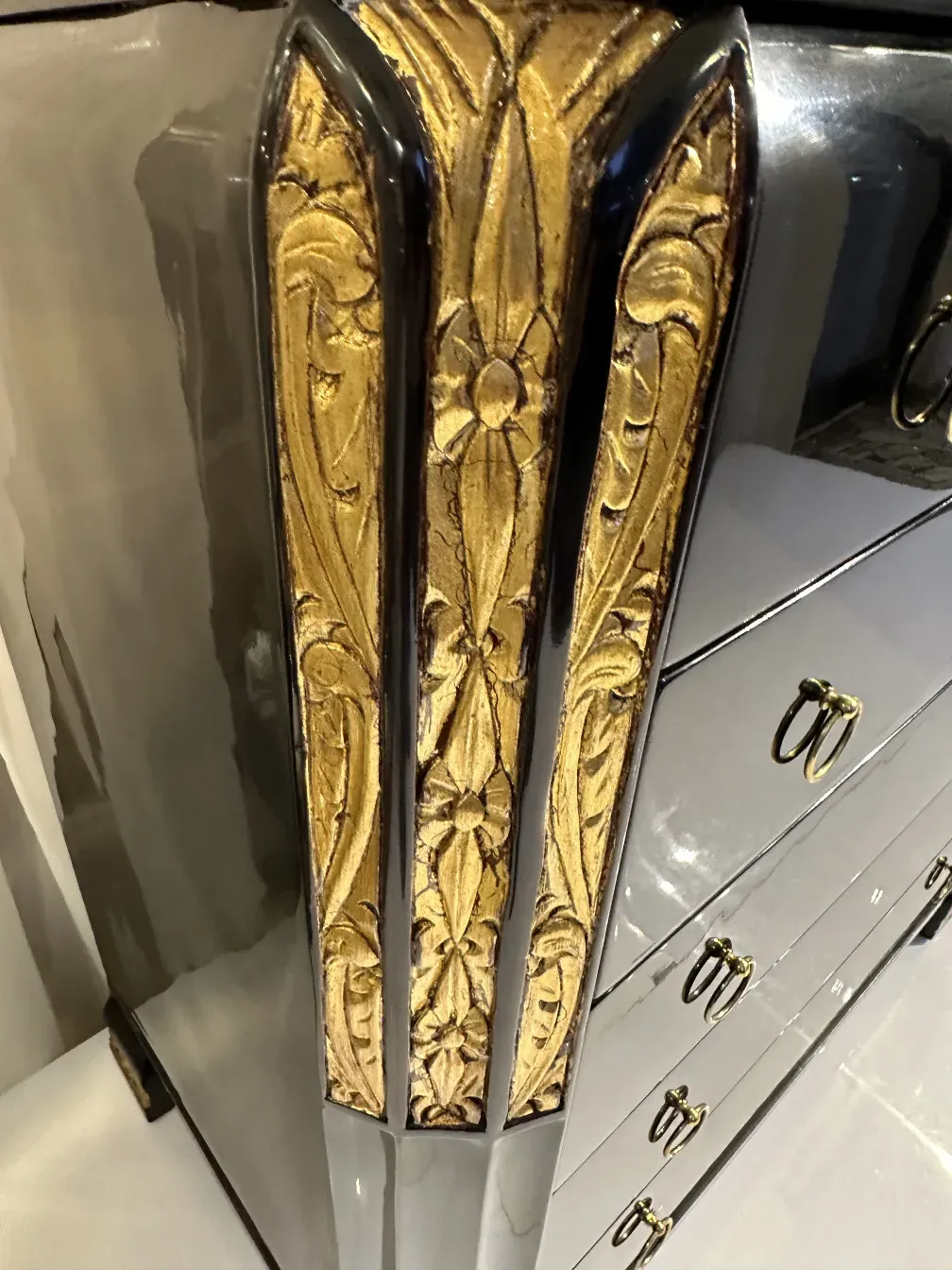 Commode antique avec des décorations dorées en relief, élégante et stylée.