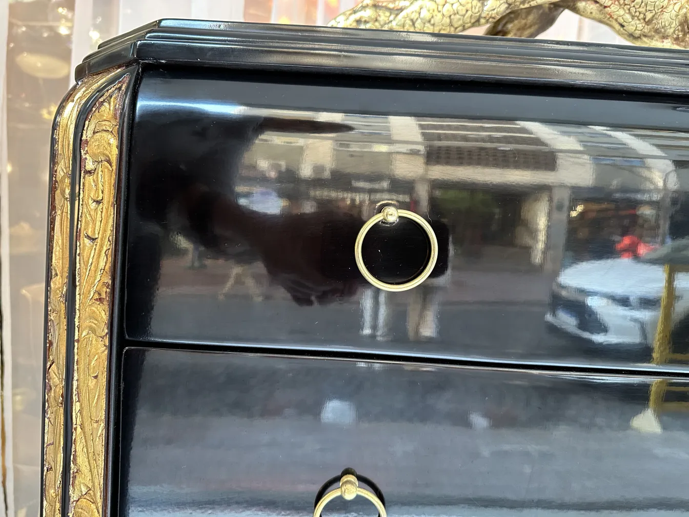 Antique cabinet with black finish and gold decorative accents.
