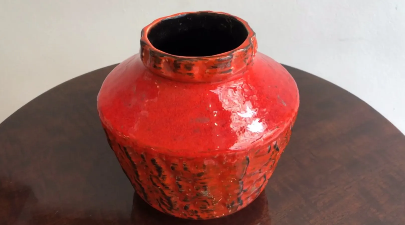 Antique red ceramic jar with unique texture.
