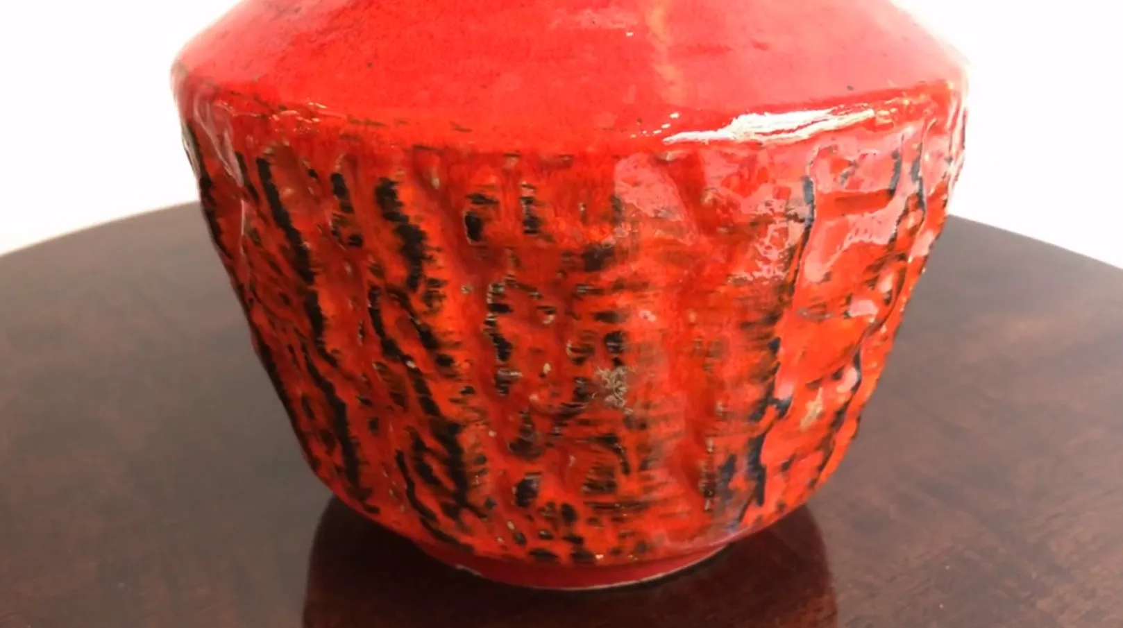 Antiga cerâmica vermelha decorativa com textura única.