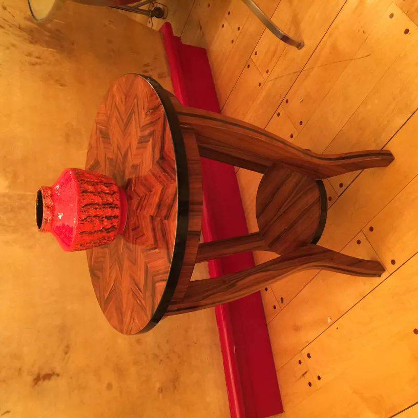 Vaso de cerâmica antiga sobre mesa de madeira com padrões.