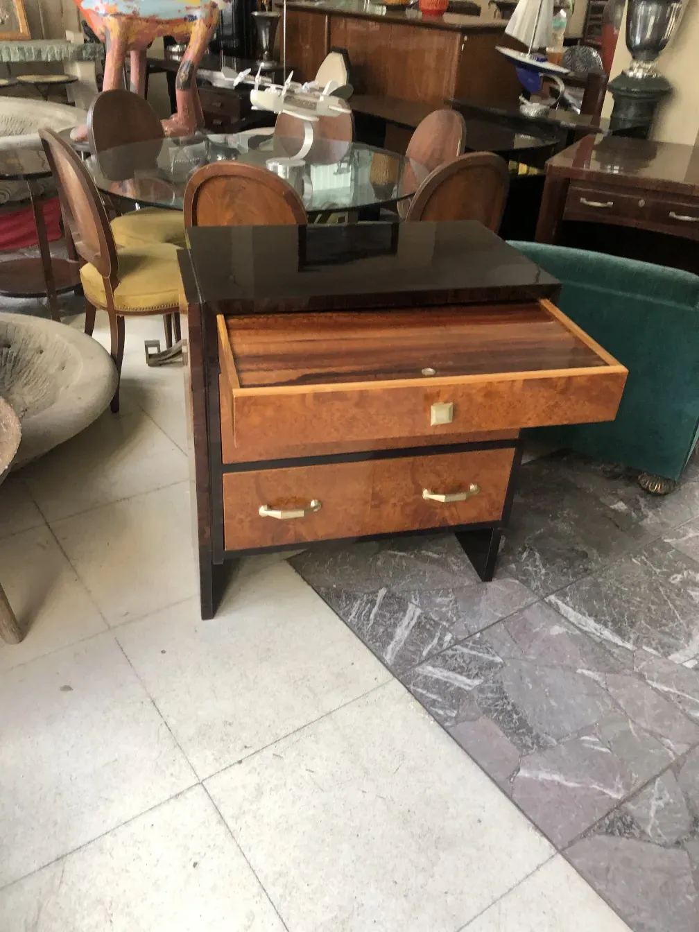 Antique cabinet with two drawers and glossy finish, surrounded by vintage furniture.