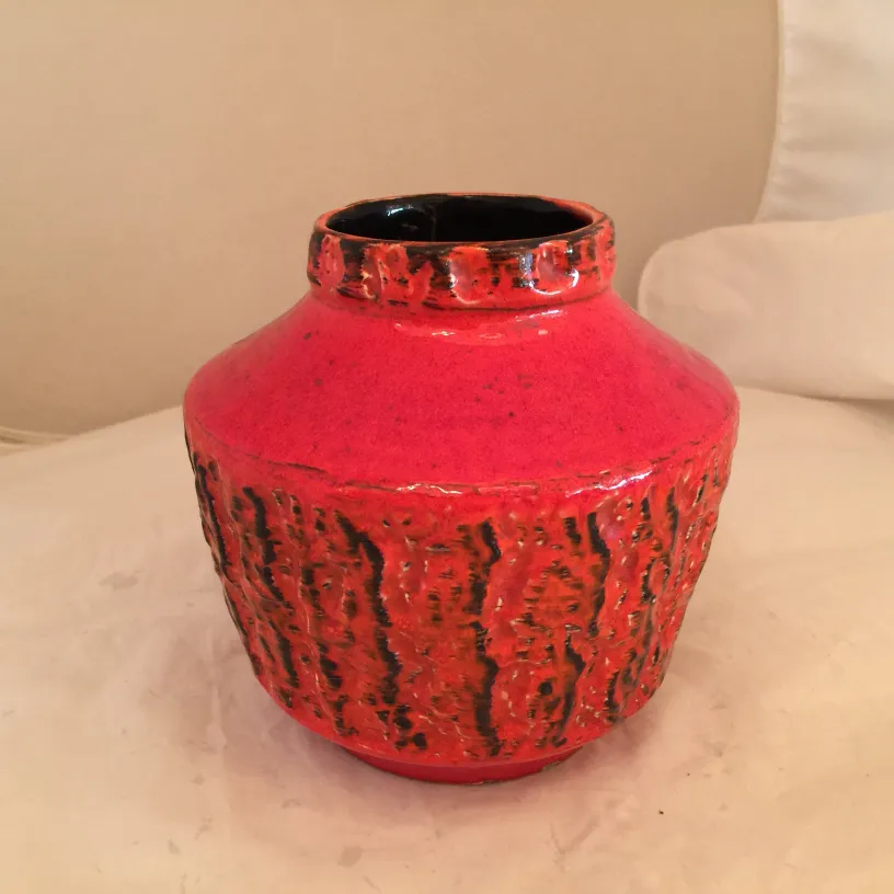 Antike Keramikvase, leuchtend rote Farbe mit Textur.