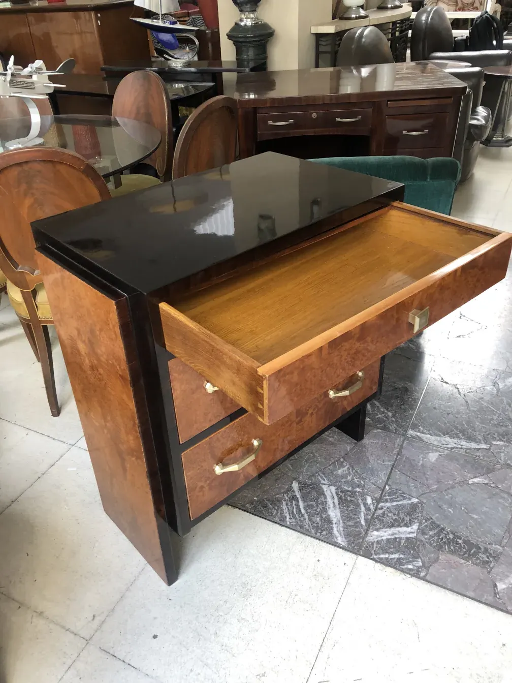 Comoda antigua de madera con tiradores dorados, en un ambiente vintage.