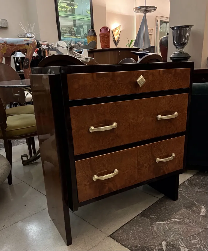 Cassettiera antica in legno con due cassetti e maniglie dorate.