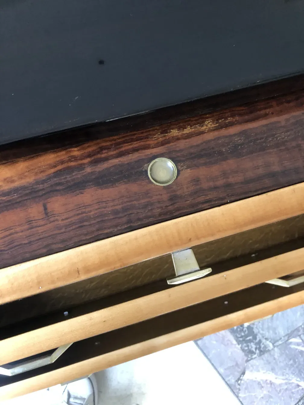 Comoda antigua de madera con dos cajones visibles.