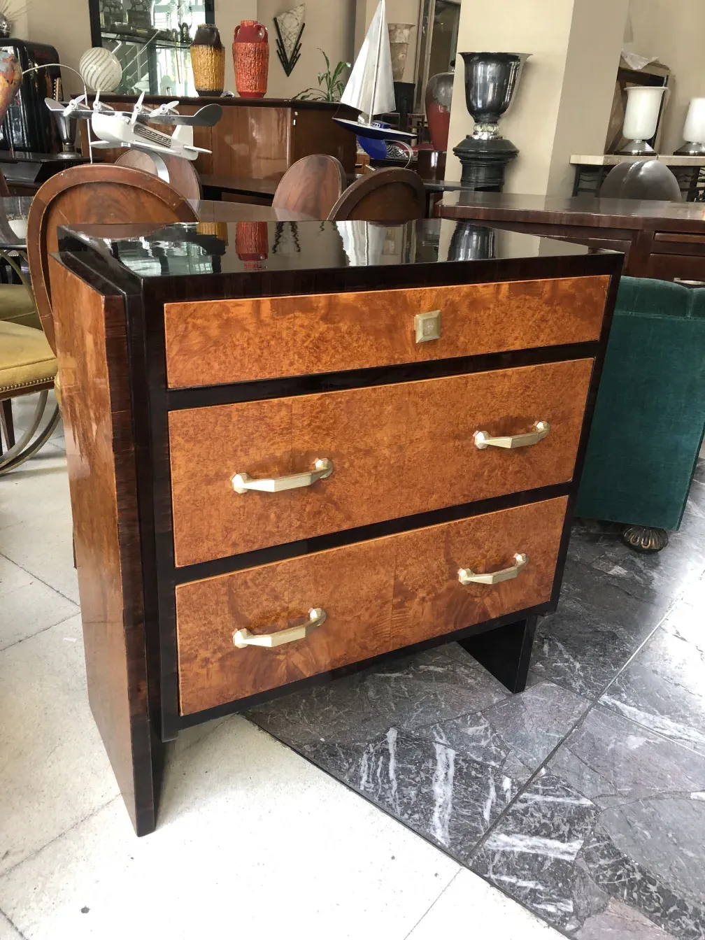 Cassettiera antica con tre cassetti in un ambiente elegante