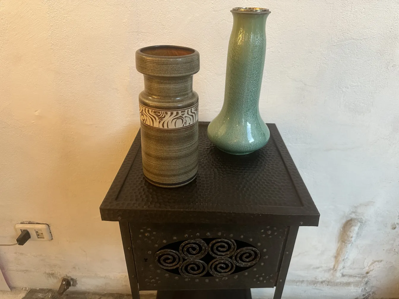 deux vases en céramique ancienne sur une table noire