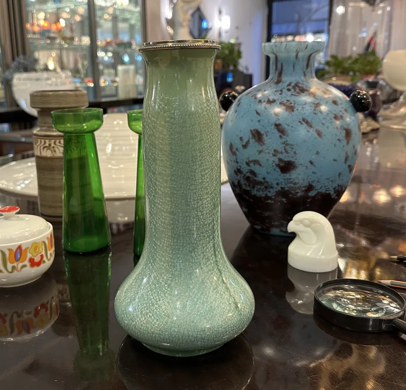 Antique green ceramic vase with a textured surface.