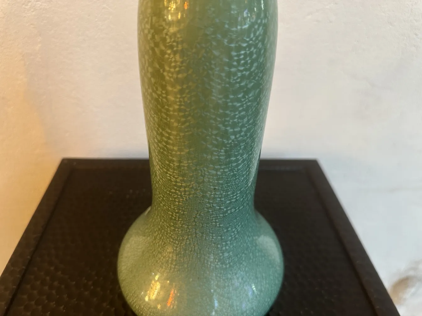 Vaso antigo de cerâmica em verde brilhante com textura.