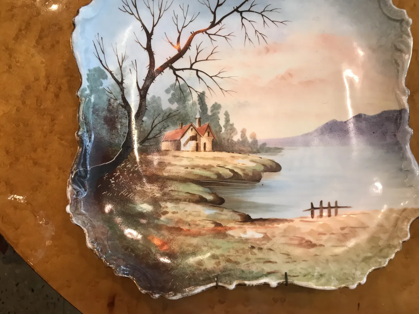 Antique ceramic plate featuring a hand-painted landscape.