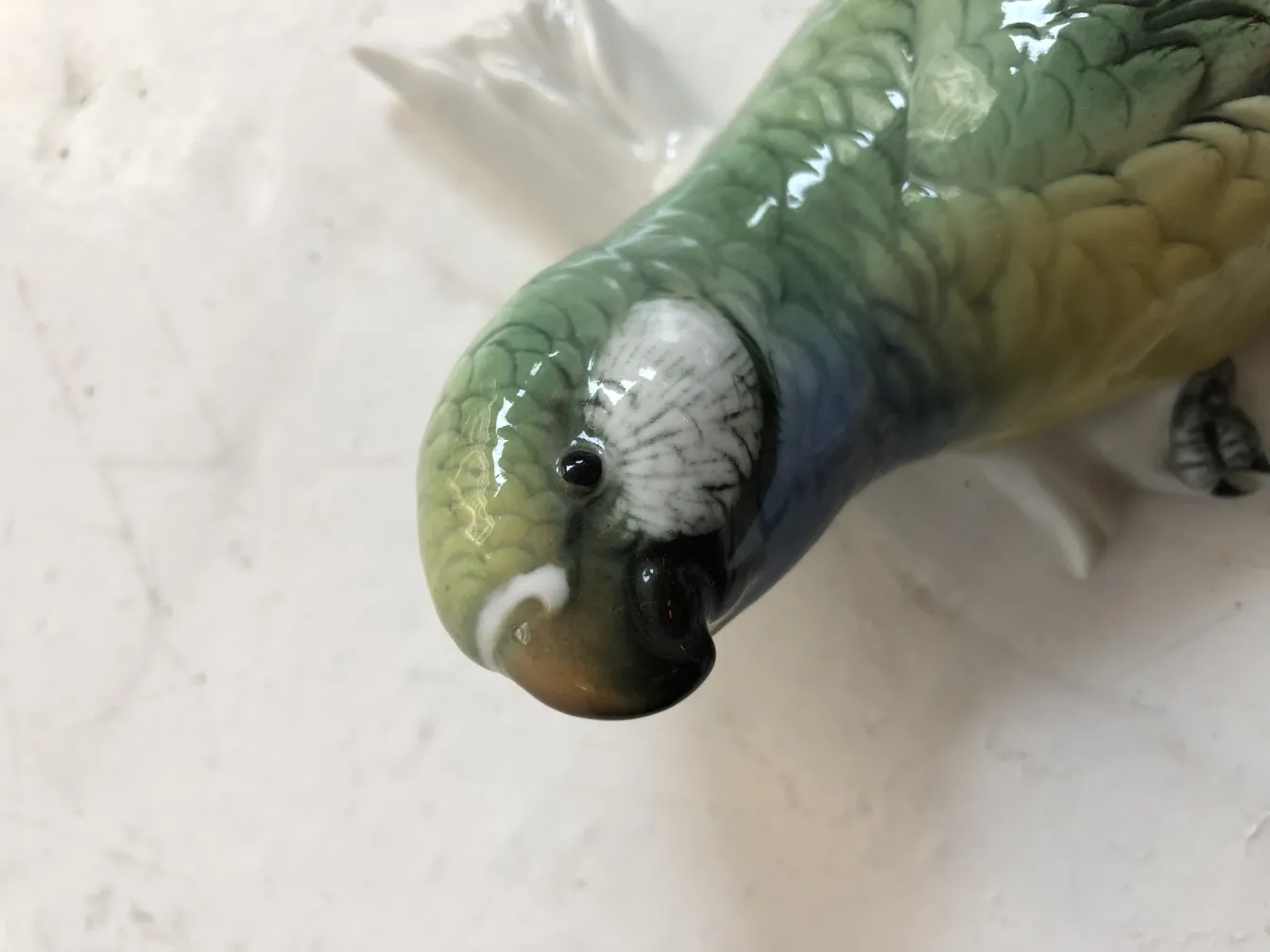 antique ceramic sculpture in the shape of a colorful bird