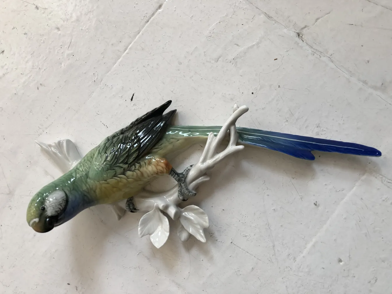 古代の陶器が白い枝の上に鳥を描いている