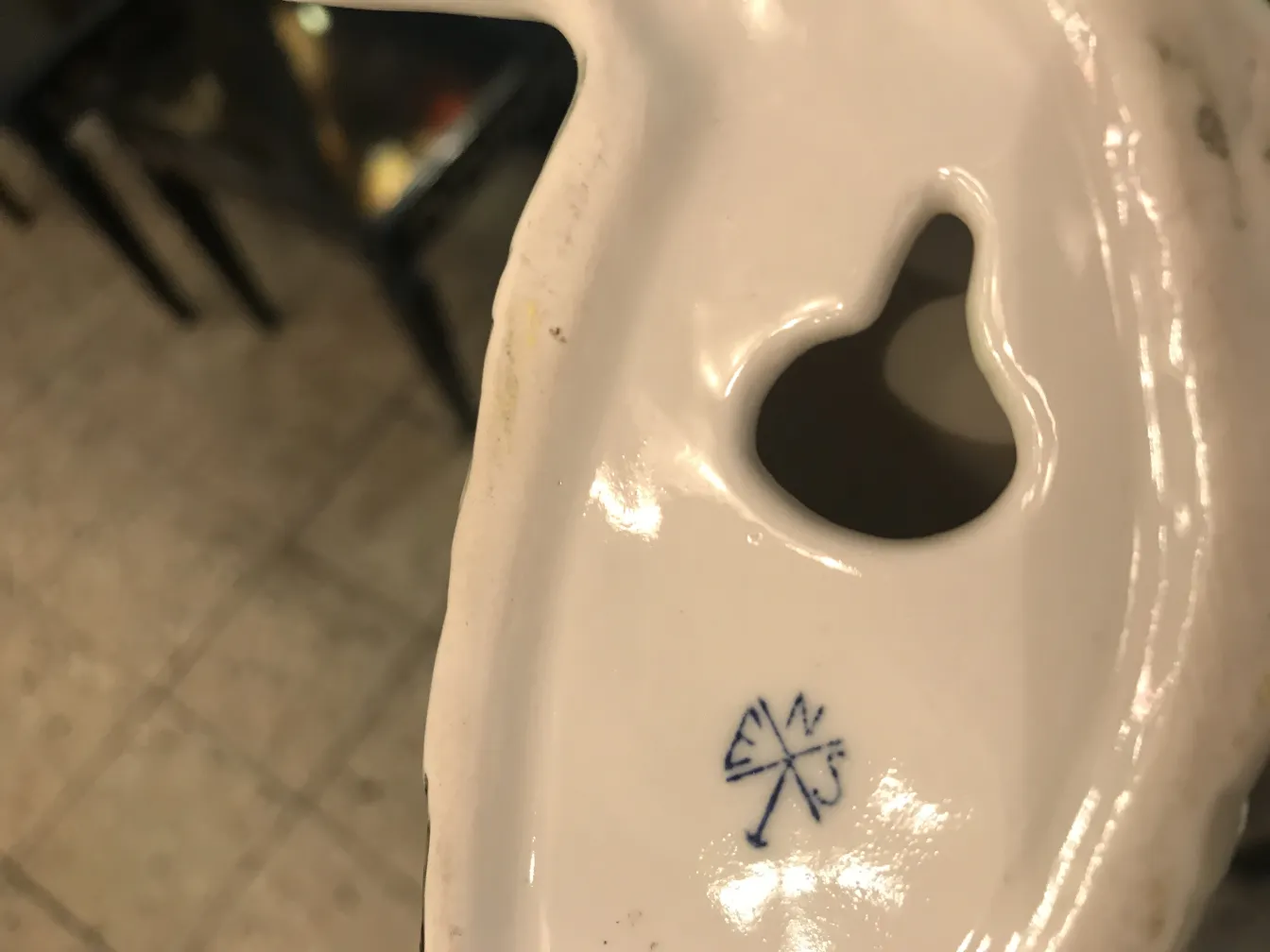 Ceramica decorativa antica con dettagli eleganti su sfondo chiaro.