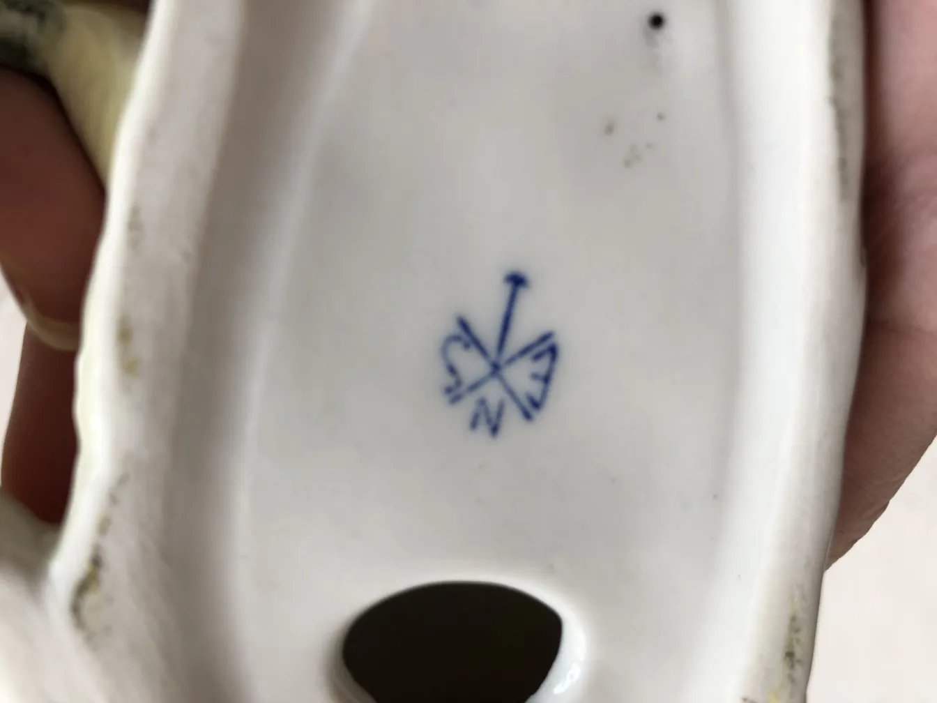 Ceramica antica con sigillo blu visibile, sfondo bianco.