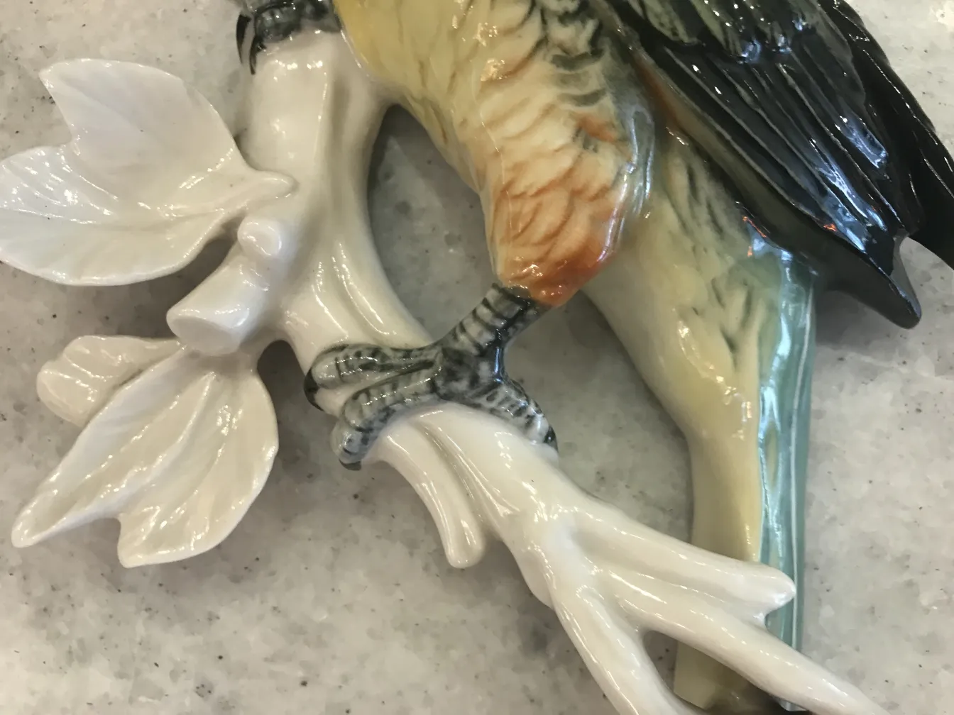 白色树枝上的古董陶瓷鸟雕像