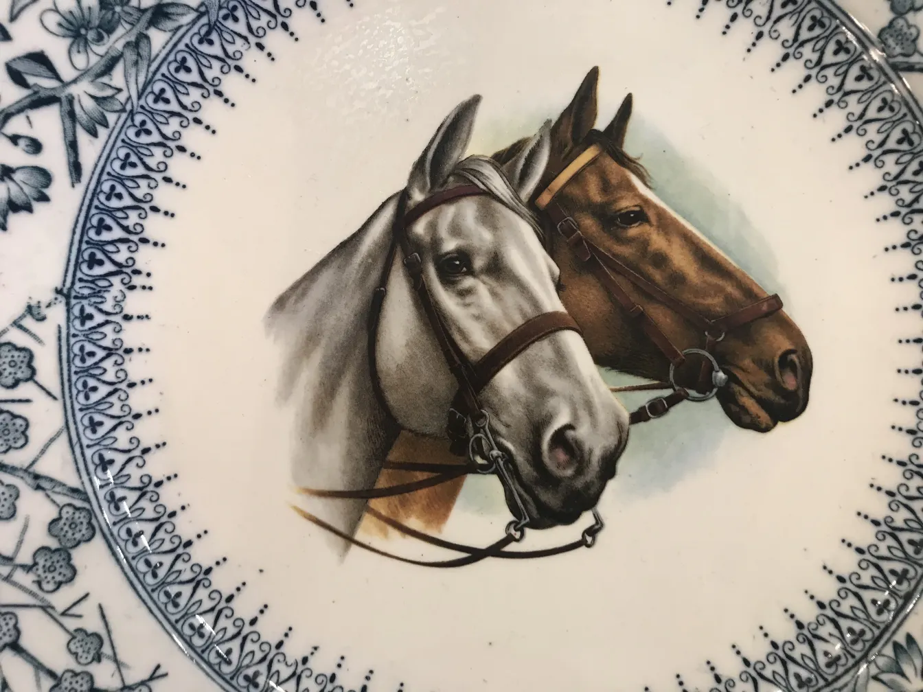 Plato de cerámica antigua con dos caballos retratados