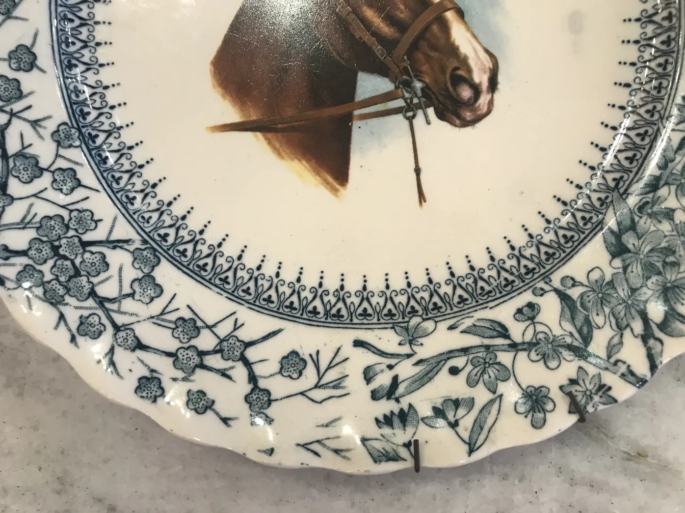 Plato decorativo antiguo de cerámica Gloucester con un caballo y flores azules.