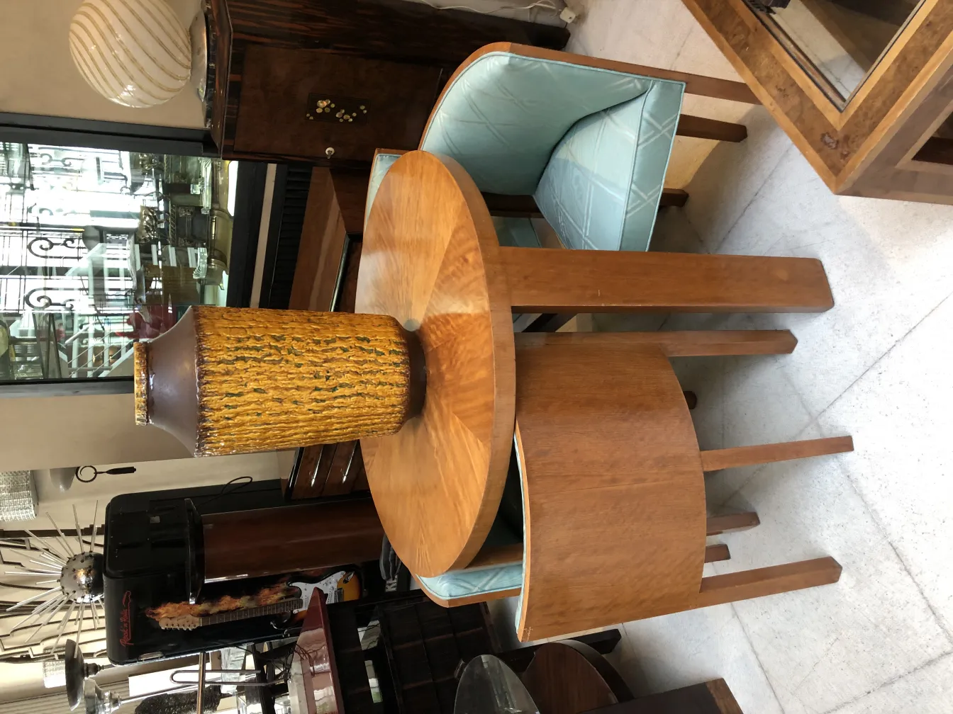 Vaso de cerámica antigua con textura dorada sobre mesa de madera.