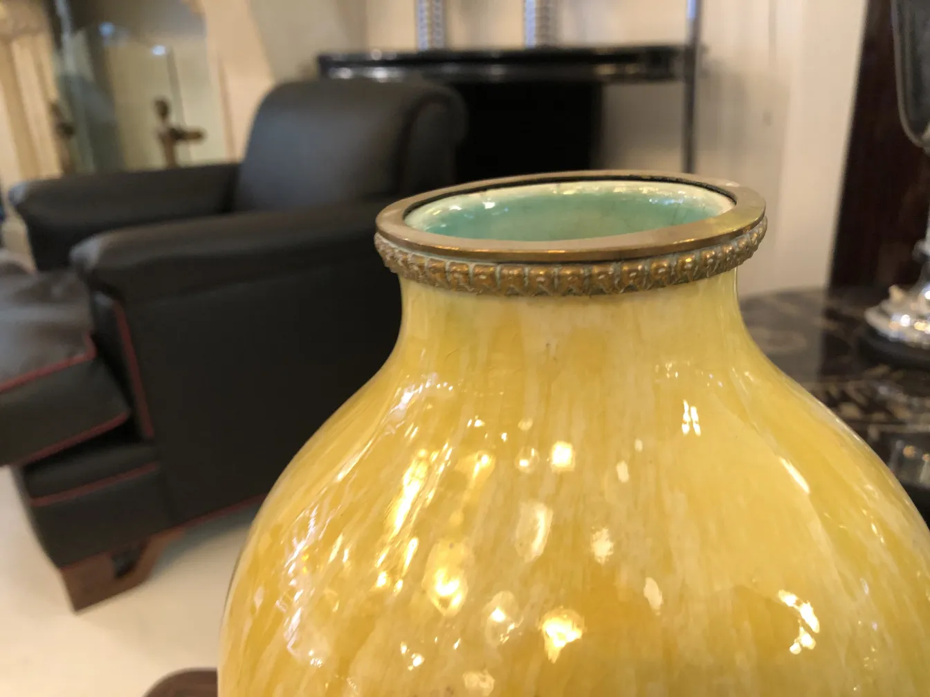 Vaso cerâmico antigo com detalhes em ouro e design único em um ambiente elegante.
