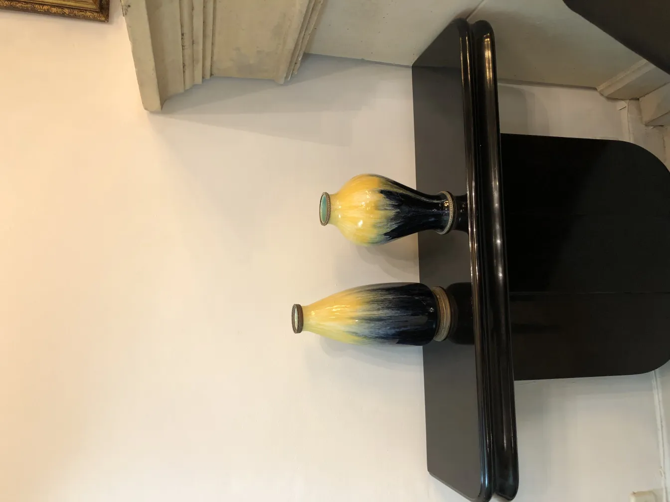 Due vasi di ceramica antica dai colori vivaci su un tavolo nero.