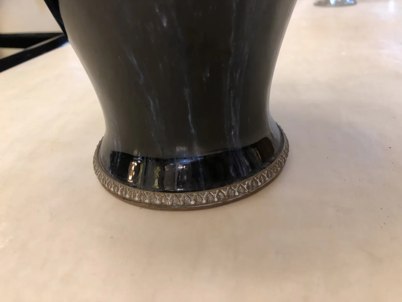 Antique ceramic vase with decorative silver base.