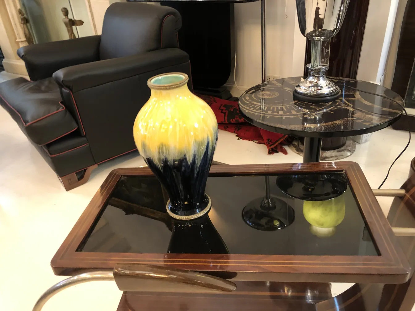 Jarrón antiguo de cerámica Boch frères keramis en una mesa de diseño moderno.