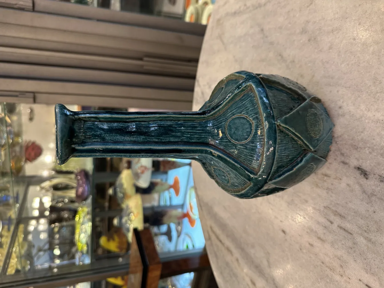 Antique green ceramic vase with intricate details, decorative background.