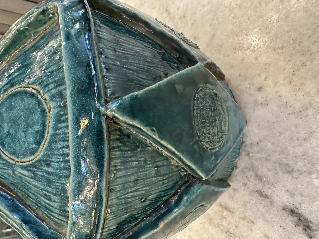 Ceramica antiga artesanal verde com texturas únicas.