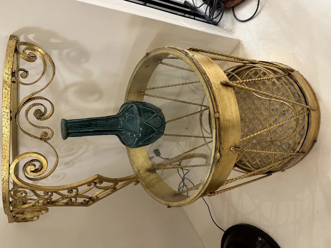 Vase en céramique antique avec motif vert sur table dorée.