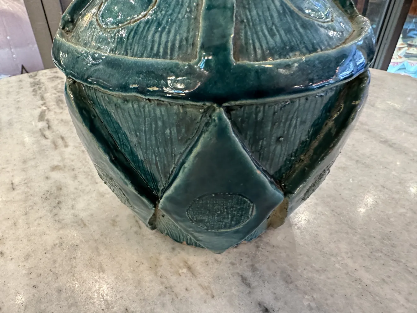 Jarrón de cerámica antigua en tonos azules y texturizados.