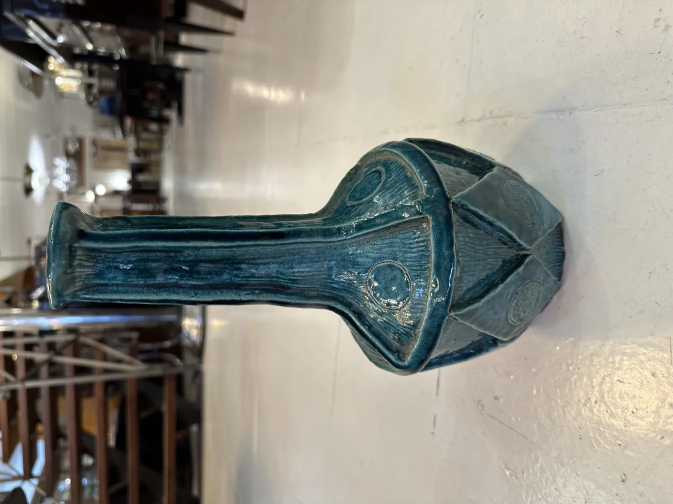 Vase en céramique bleue avec des détails décoratifs dans un cadre ancien.