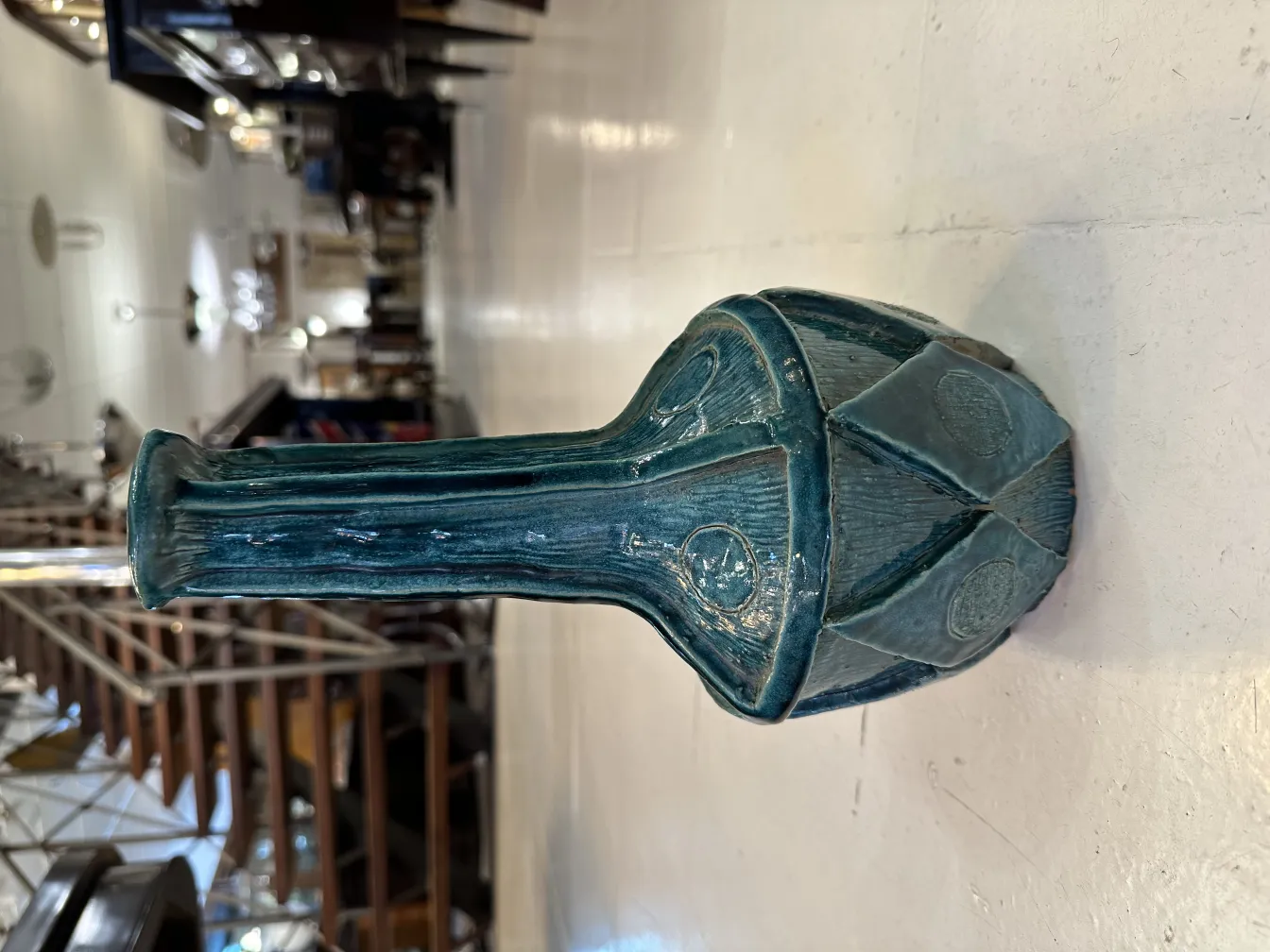 Vase en céramique bleue avec un design détaillé sur fond clair.