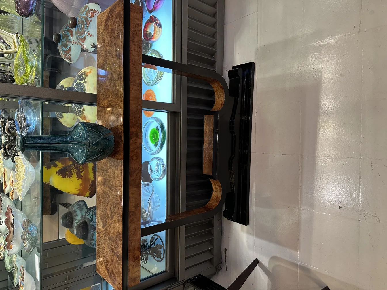 Vaso azul de cerámica antiga em exibição com itens coloridos