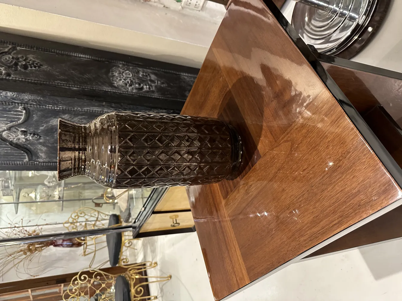 Vaso cerâmico antigo de cor marrom com textura, ambiente elegante.