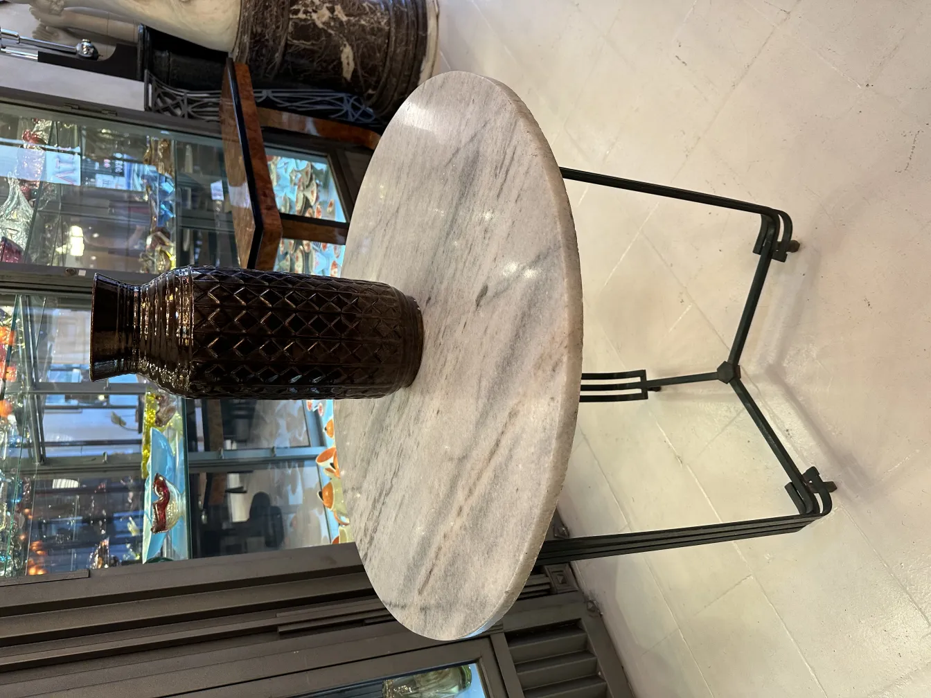 Vaso decorativo de cerámica antiga em mesa de mármore. Ambiente elegante.