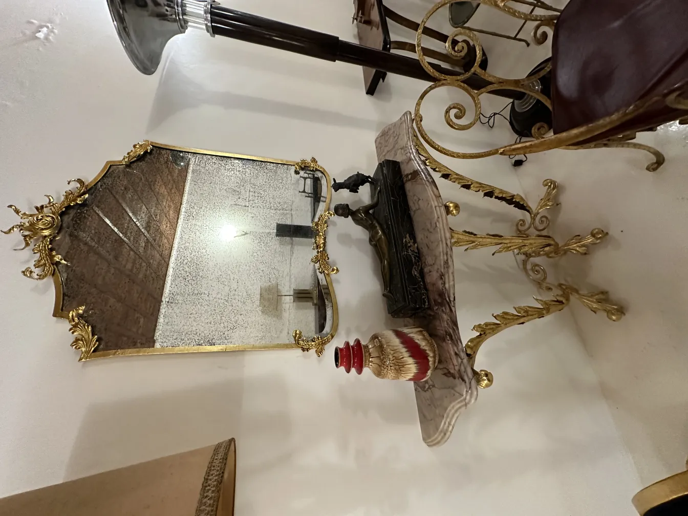 Espejo antiguo con marco dorado y cerámica decorativa.