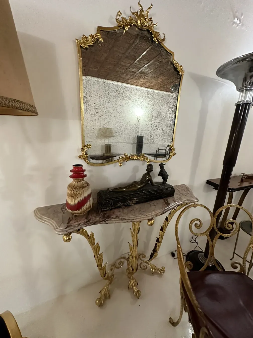Espejo antiguo con marco dorado y decoración, mesa con cerámica