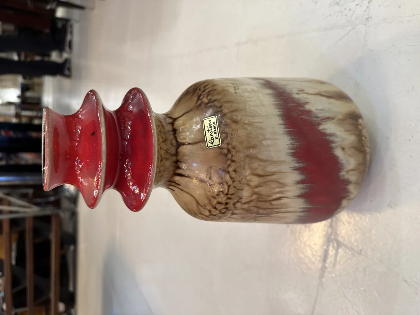 Vaso de cerâmica antiga em tons marrons e vermelhos, decorativo.