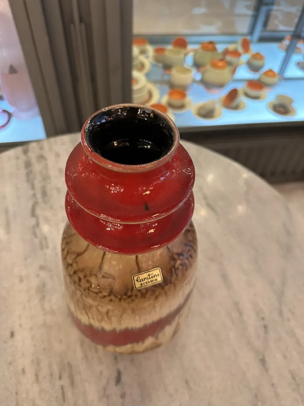 Antique ceramic vase with red and brown finish.