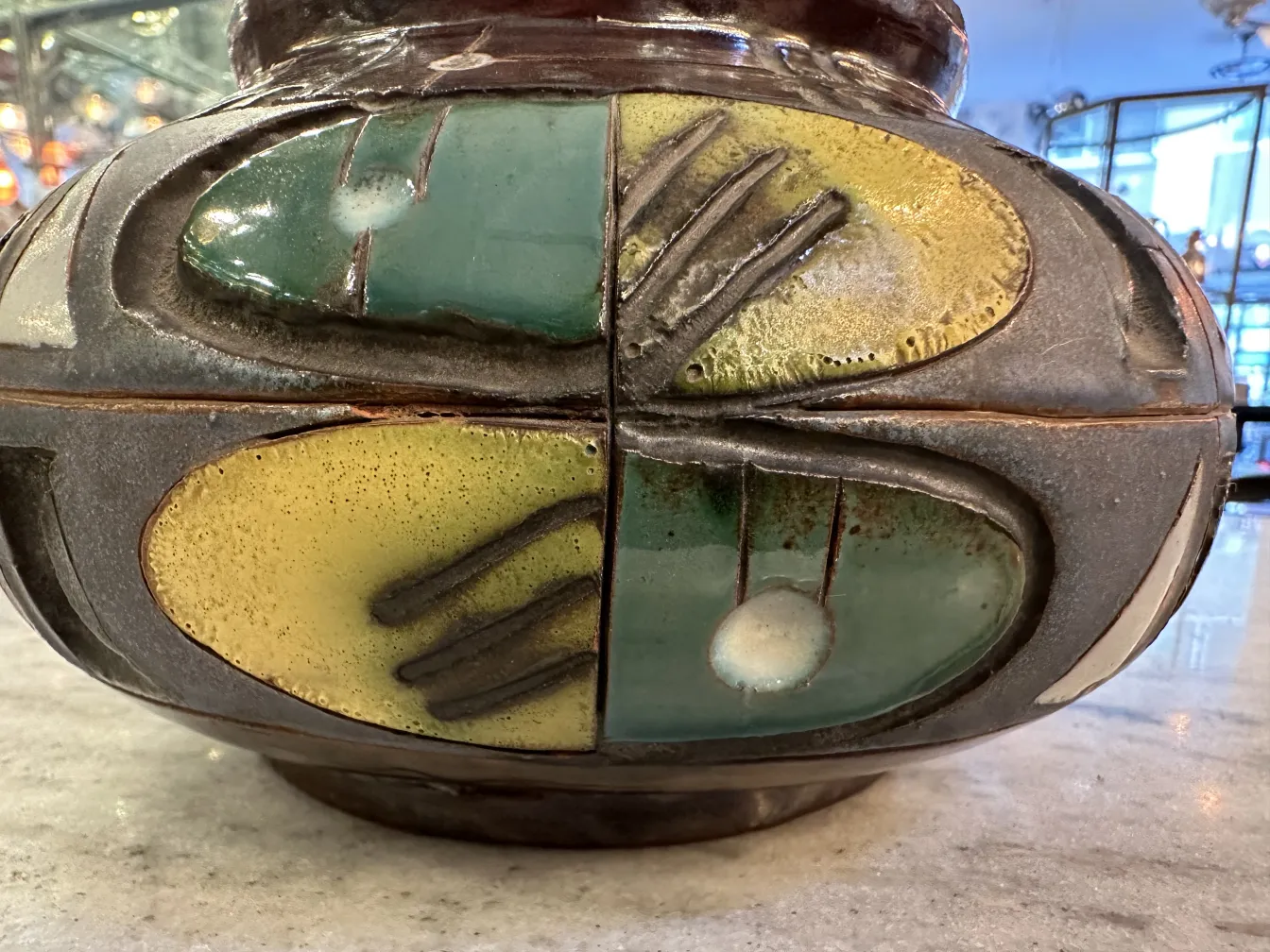 Un objet en céramique ancienne décoré de couleurs vives et de détails artistiques