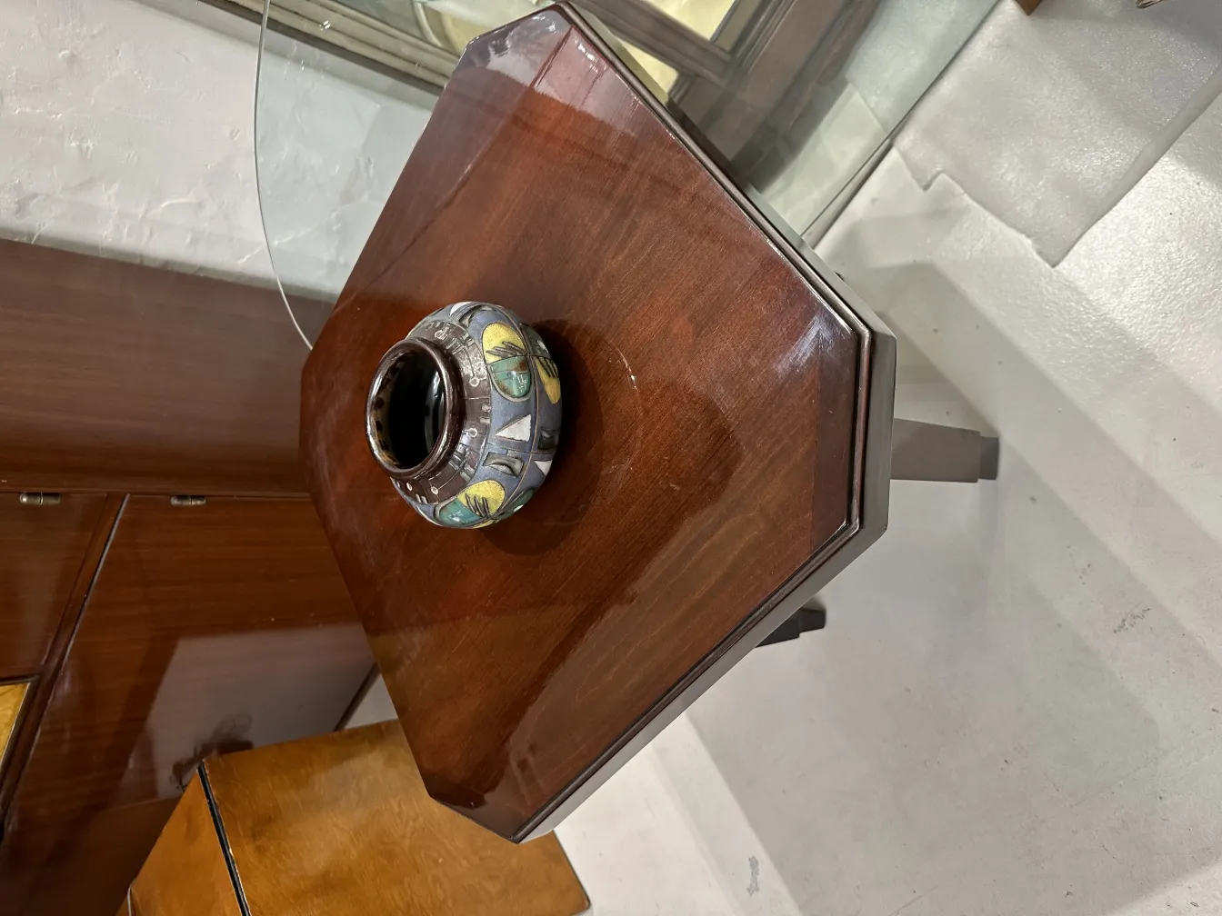 Ceramica antica decorativa con bottoni di luce, posta su un tavolo di legno.