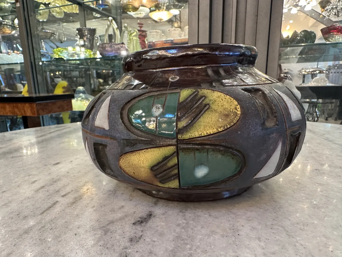 Antica ceramica decorativa con forme colorate in un ambiente elegante.