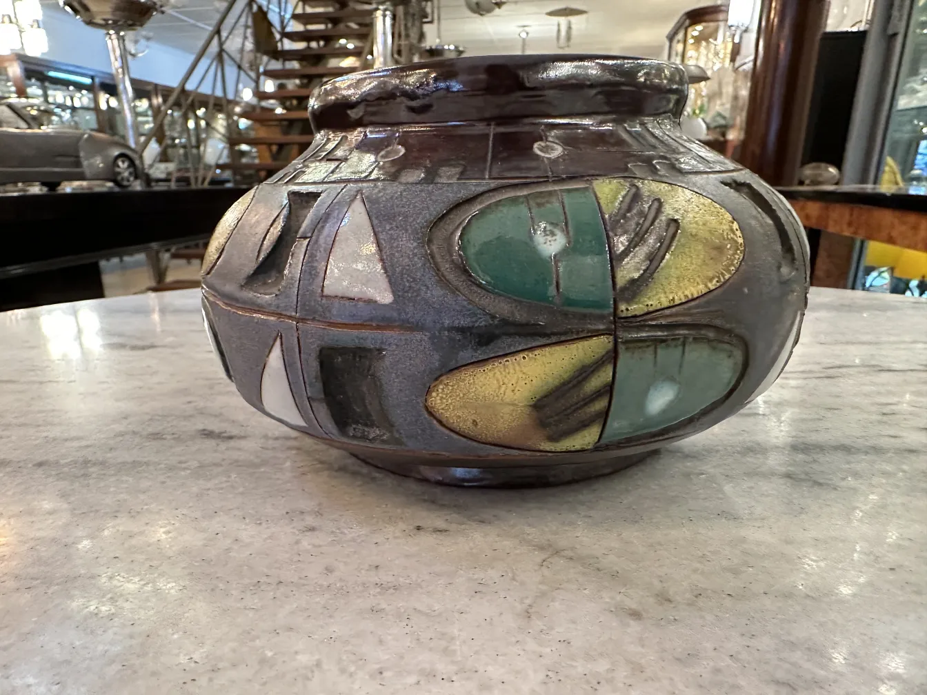 Vaso di ceramica antica con motivi colorati su tavoli in marmo