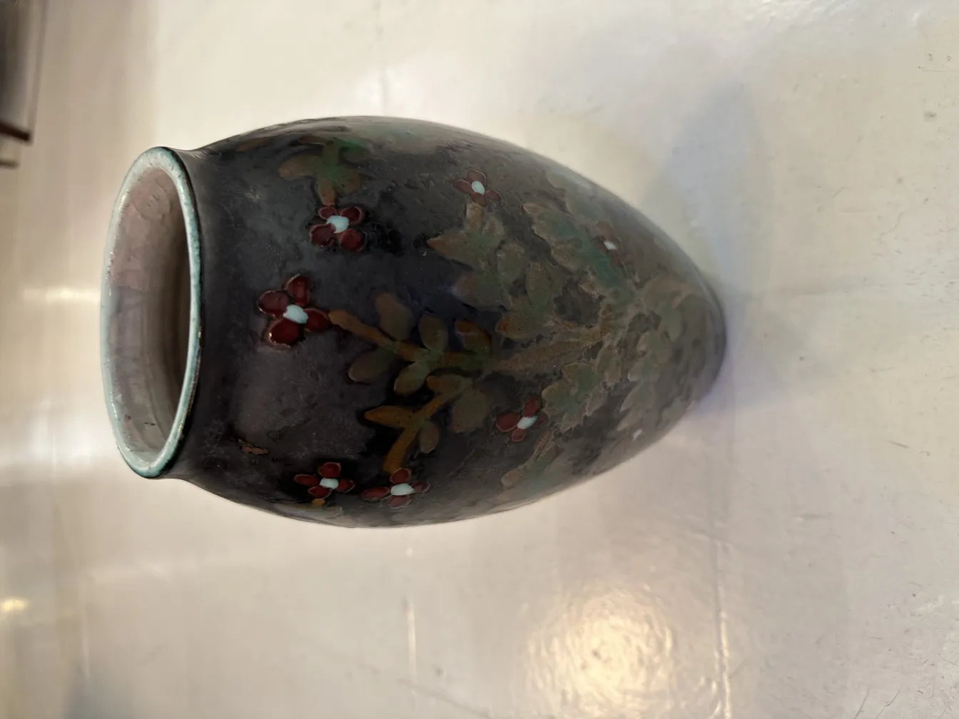 Vaso de cerámica antigua decorado con flores rojas y verdes