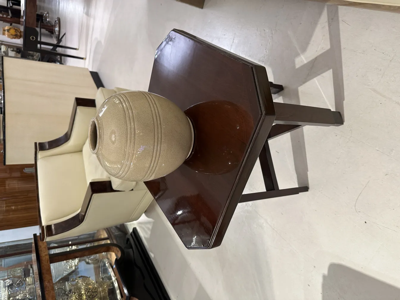 Vaso in ceramica antica su un tavolo di legno con sedie sullo sfondo