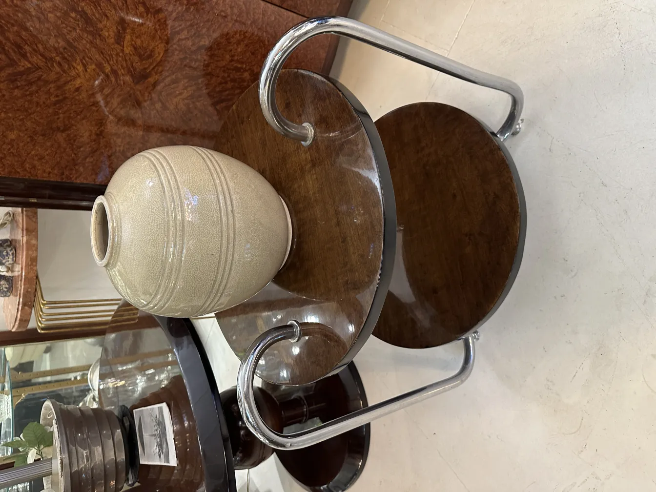 Vaso antico in ceramica con design decorativo in tonalità chiare, su un tavolo di legno.