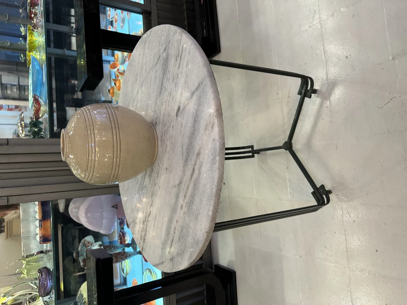 Vaso de cerâmica antiga em mesa redonda decorativa.