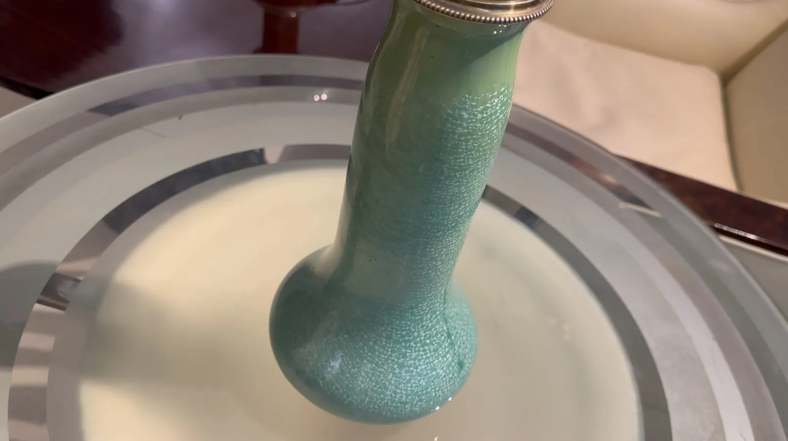 Antike Keramikflasche mit blauer Textur auf hellem Hintergrund.