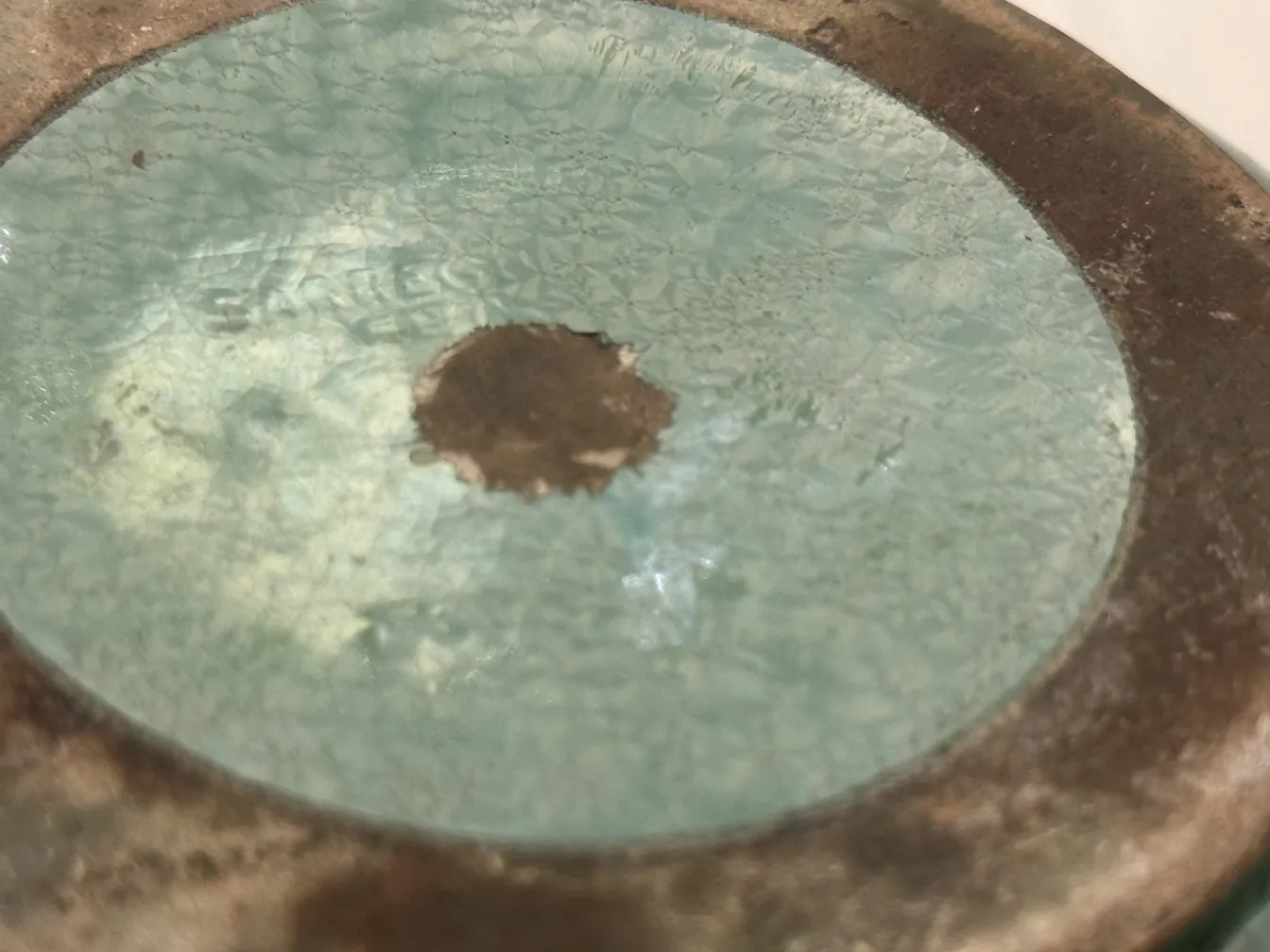 Copo azul antigo de cerâmica com detalhes craquelados na base